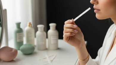An expert guide on how to test and choose perfume, illustrated by a close-up of a woman thoughtfully smelling a perfume test strip to avoid costly mistakes, with various bottles in the background.