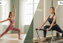 A split-screen, photorealistic image comparing yoga and Pilates. On the left, a woman in her forties wearing a dusty rose outfit is in the Warrior II yoga pose inside a serene studio with sage green walls. On the right, the same woman, dressed in charcoal activewear, performs an exercise on a Pilates reformer in a modern, cream-walled studio.