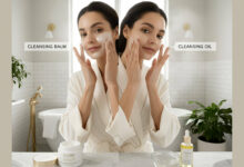 A gorgeous woman in a stylish bathroom compares Elemis Pro-Collagen cleansing balm with a cleansing oil during her skincare routine.