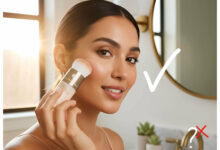 A gorgeous woman in a well-lit bathroom applies Colorescience powder SPF with a built-in brush, demonstrating its application and addressing whether powder SPFs provide real protection.