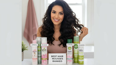 Ranking the best drugstore hair mousses: L'Oréal, Garnier, and Herbal Essences cans displayed on a stylish vanity, with a gorgeous woman showing off her voluminous hair.