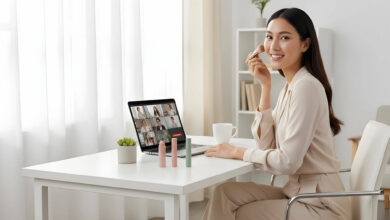 A confident woman at her modern home office desk applies quick makeup from a 5-minute kit before an online meeting.