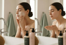 a woman performing a double cleanse routine in a bright bathroom, first applying a cleanser to her face and then rinsing with water, exploring if it's necessary for acne-prone skin.