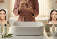 a woman in a bright, spacious room, thoughtfully comparing a skincare product with essential oil bottles, considering if using essential oils in skincare is a good idea
