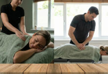 woman wearing a comfortable dusty rose sweater, smiling with relief as she gently stretches her back in a sunlit room with sage green accents