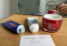 A photorealistic flat lay comparing L'Oréal, Neutrogena, and Olay retinol containers arranged on a sunlit wooden table with sage green accents