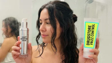 A woman in a humid bathroom holding a high-end silver bottle labeled "Luxury Smoothing Cream" and a generic tube labeled "Drugstore Frizz Control," comparing the two products for a humidity test