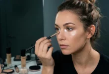 An attractive woman at a vanity mirror performing a 5-minute nighttime beauty trick for a total transformation that goes beyond the classic red lip